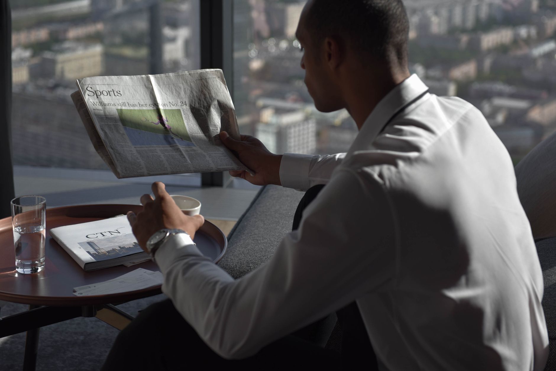 Businessman in office reading sports section, enjoying coffee with city view. — BlazeBet: Quick Wins for the Modern Player