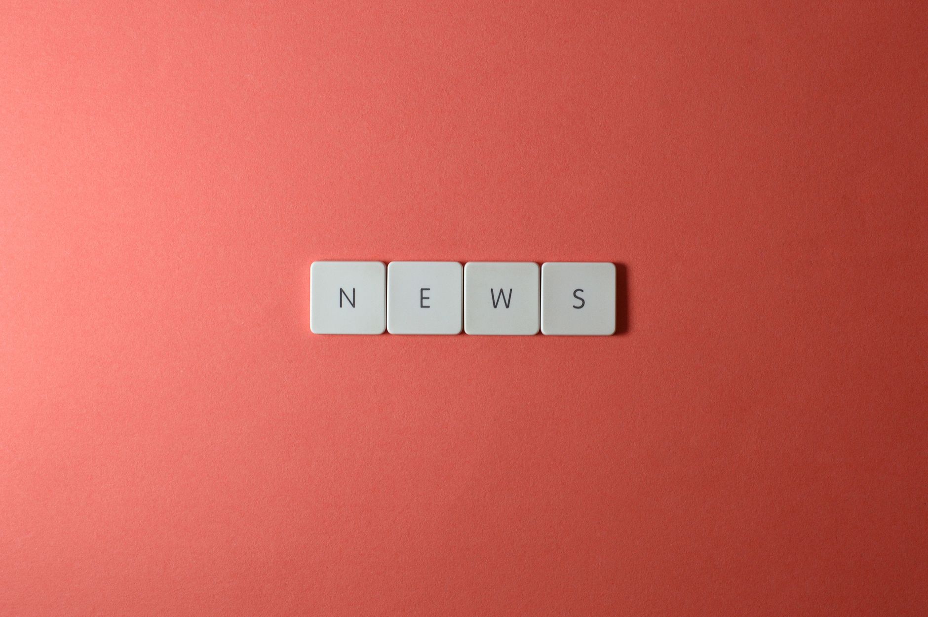 Close-up of keyboard keys spelling 'NEWS' on a red background, minimalist style. — Was macht die Community von Chicken Road C