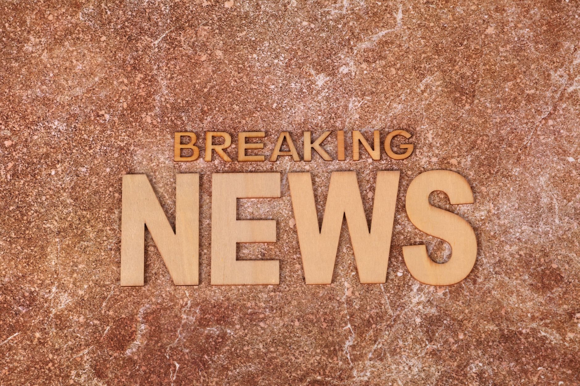 Wooden letters spell 'Breaking News' on a textured, marble-like background. Ideal for newsworthy content. — Wie registriere i